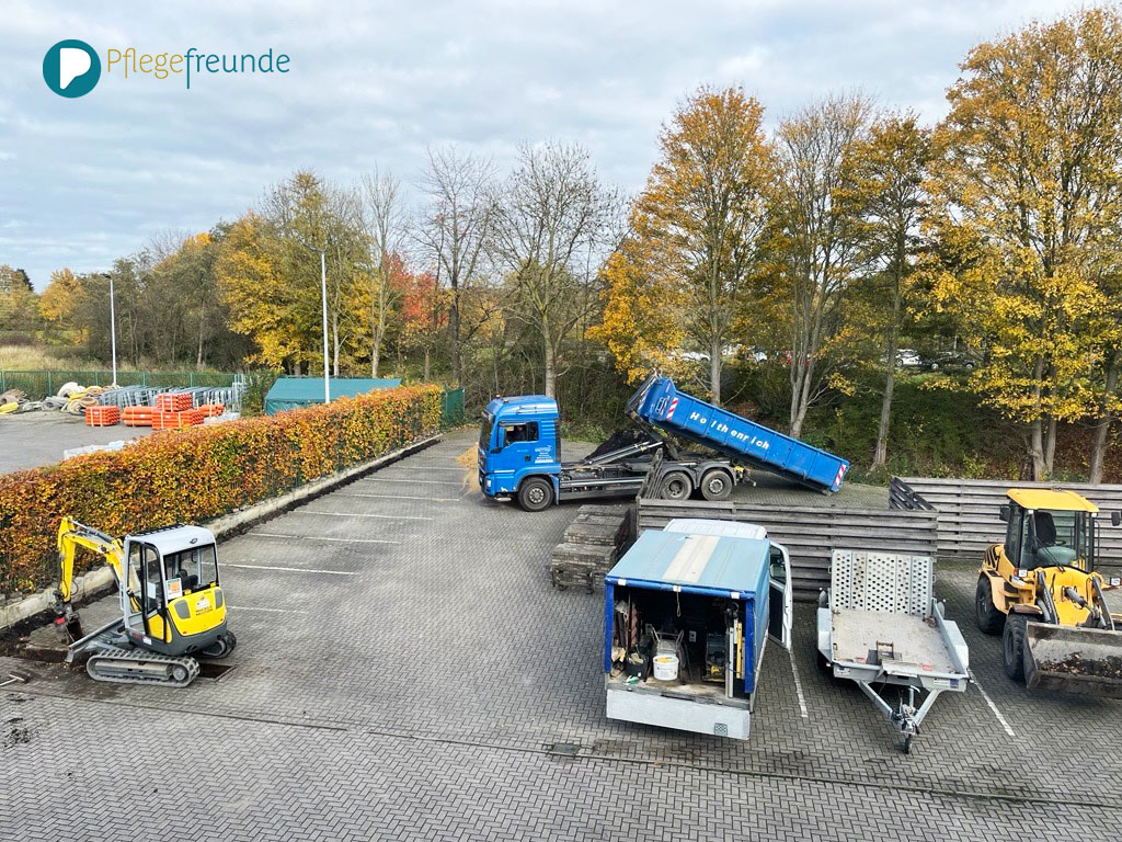Parkplatz von oben mit Bagger, LKW und Transporter