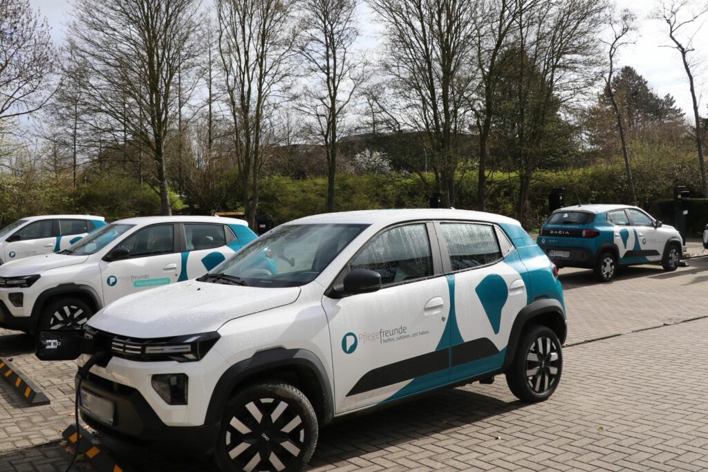 E-Auto auf dem Parkplatz. An der Ladesäule angeschlossen.