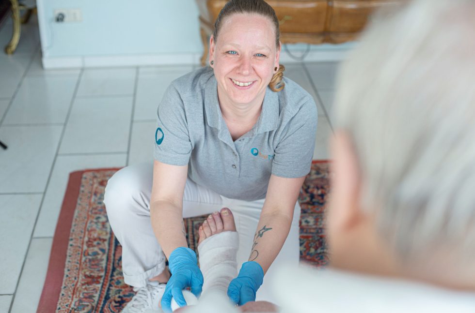 Wundexperte behandelt das Bein eines Patienten
