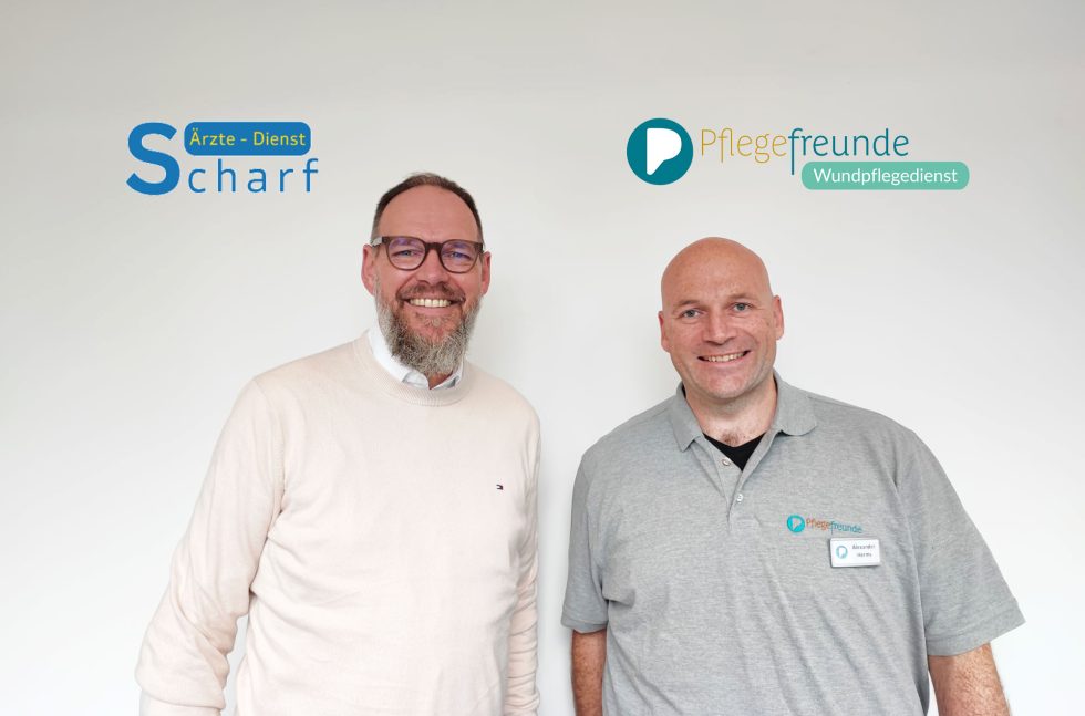 Die beiden Geschäftsführer Ralf Rottmann (Ärzte-Dienst Scharf GmbH & Co.KG) und Alexander Herms (Pflegefreunde) lächeln in die Kamera